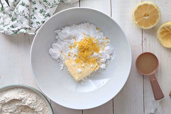 Popękane ciastka cytrynowe masło z cukrem i skórką z cytryny przed ich miksowaniem