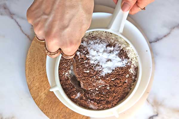 Babka Red Velvet przesiewanie przez sitko mąki z kakao na babkę red velvet