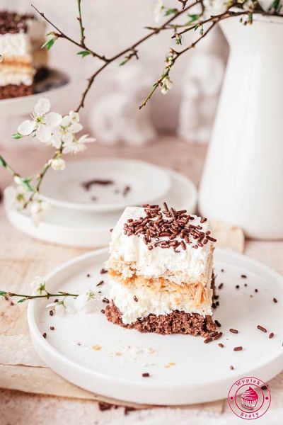 kawałek ciasta czekoladowego z kremem śmietankowym, herbatnikami i kajmakiem łatwy przepis na warstwowe ciasto z kremem i kajmakiem