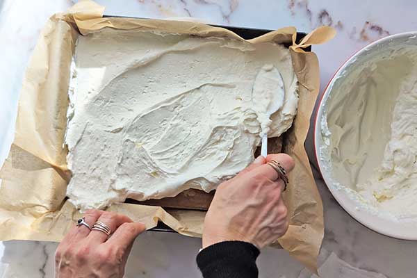 Ciasto karmelowa niespodzianka wykładanie połowy kremu mascarpone na biszkopt