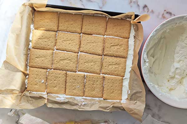 Ciasto karmelowa niespodzianka wykładanie warstwy herbatników na krem mascarpone
