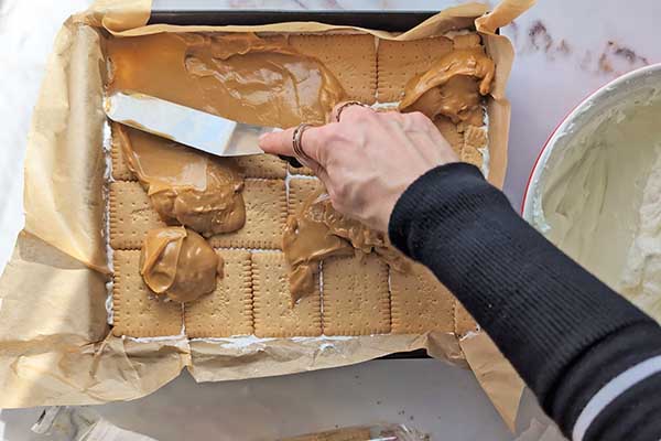 Ciasto karmelowa niespodzianka wykładanie masy kajmakowej na herbatniki