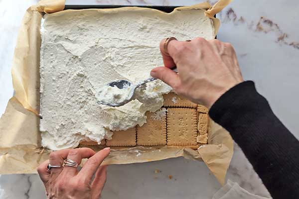 Ciasto karmelowa niespodzianka wykładanie kremu mascarpone na warstwę herbatników