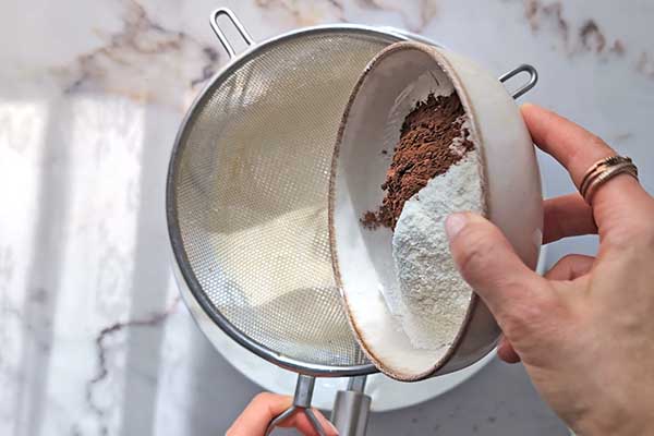 Ciasto karmelowa niespodzianka przesiewanie mąki z kakao