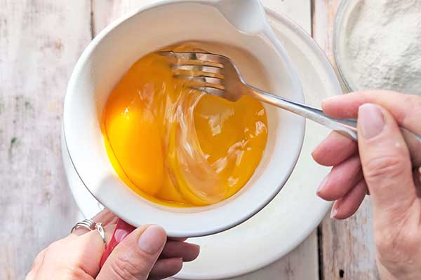 Puszyste i wilgotne ciasto na kremówce mieszanie jajek przed dodaniem ich do ciasta