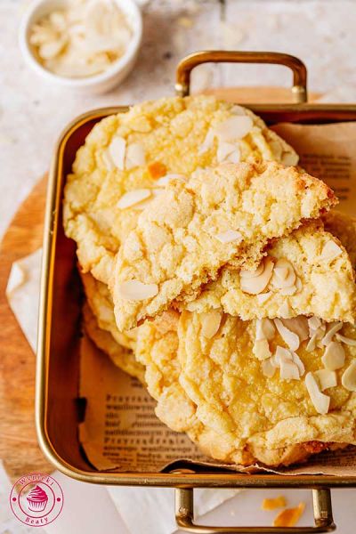 zbliżenie od góry na pojemnik z ułożonymi w nim chrupiącymi ciasteczkami almond croissant pomysł na łatwe migdałowe ciastka z masą migdałową i płatkami migdałów