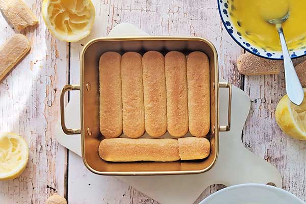 Limoncello tiramisu układanie nasączonych biszkoptów w formie