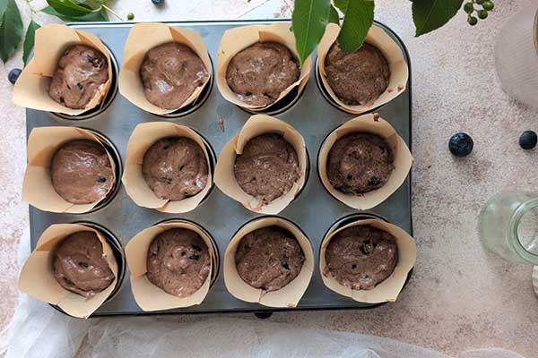 Czekoladowe muffiny z borówkami muffiny nałożone do papilotek do pieczenia