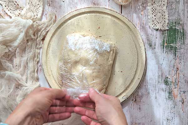 Tarta galette z borówkami zawijanie kruchego ciasta w folię spożywczą przed jego schłodzeniem