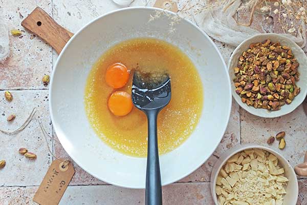 Ciastka z pistacjami i białą czekoladą mieszanie ciasta z jajkami