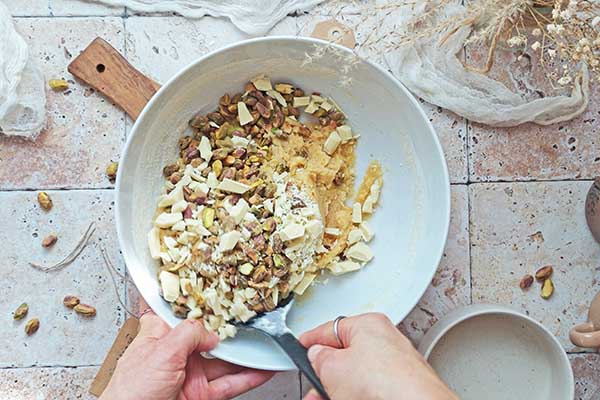 Ciastka z pistacjami i białą czekoladą mieszanie ciasta na ciastka z posiekanymi pistacjami i białą czekoladą