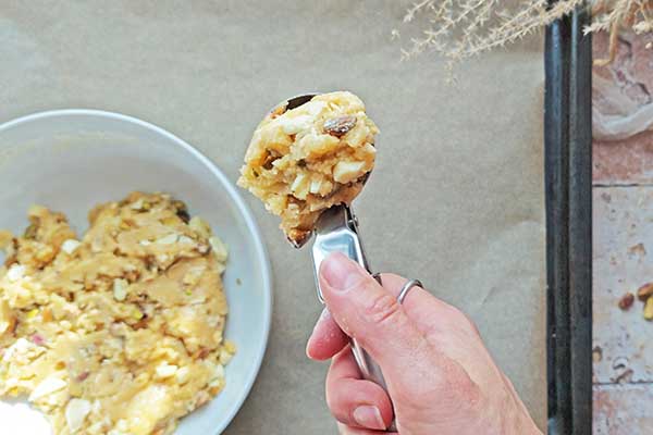 Ciastka z pistacjami i białą czekoladą nabieranie porcji ciasta na ciastka